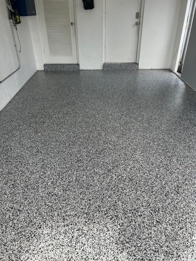 Domino Flake Epoxy Garage Floor – One-Car Garage in Fort Lauderdale, FL Close-up of Domino Flake epoxy finish on a one-car garage floor in Fort Lauderdale, FL