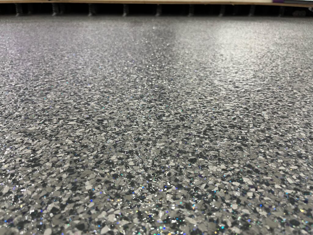 Custom Purple Epoxy Floor for Cheerleading Gym in Kendall, FL | Anti-Slip & VOC-Approved | GonzaBuilt Close-up of custom purple glitter epoxy topcoat on anti-slip VOC-approved cheerleading gym floor by GonzaBuilt in Kendall, Florida