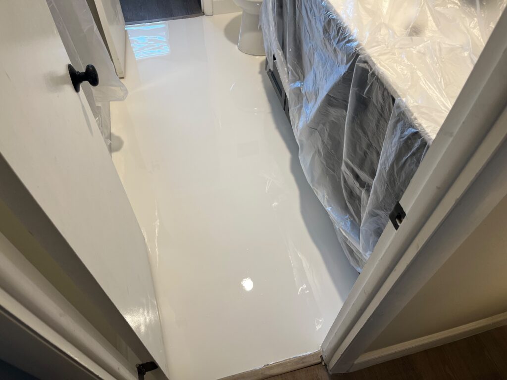 Epoxy Over Tile Apartment Bathrooms in Boca Raton, FL | Seamless White Epoxy Floors | GonzaBuilt Seamless solid white epoxy floor applied over existing tile in Boca Raton apartment bathroom after professional installation by GonzaBuilt