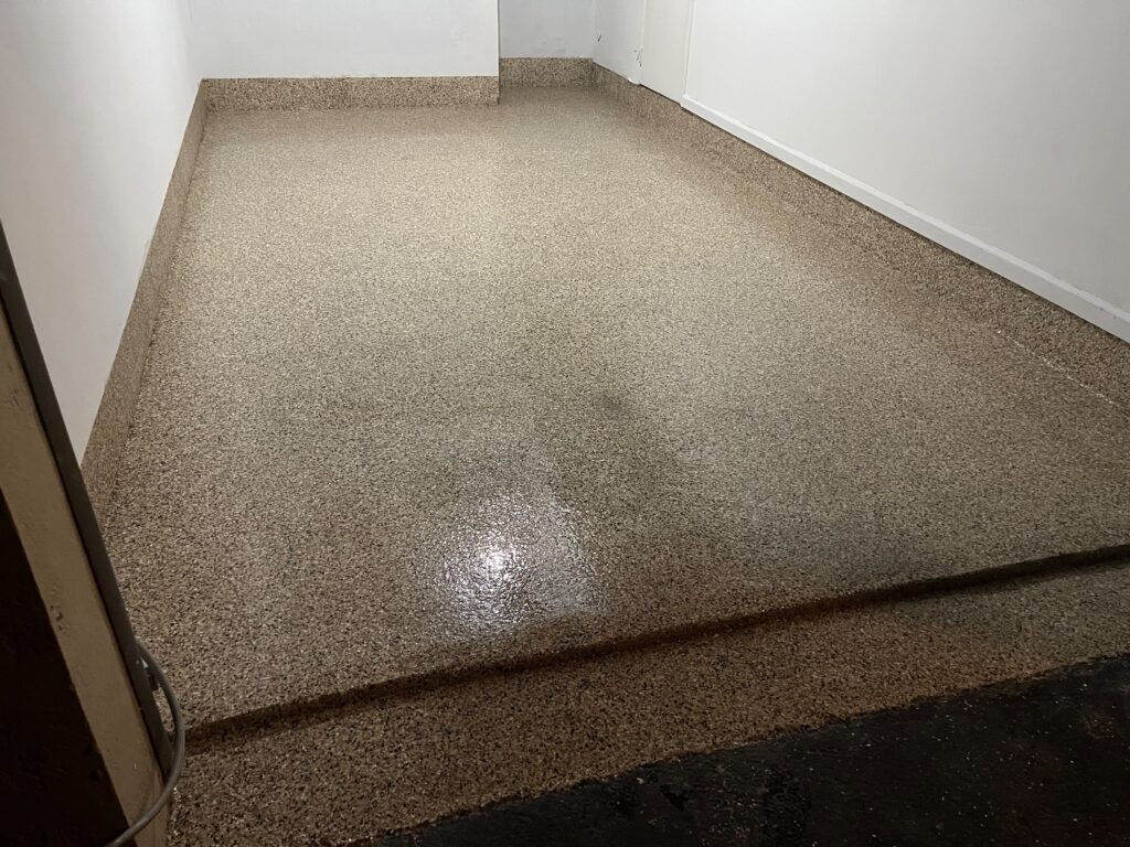 Outback Flake Garage Epoxy & 9" Cove Base in Plantation, FL | GonzaBuilt Completed Outback flake epoxy garage floor with 9-inch cove base after professional installation by GonzaBuilt in Plantation, Florida