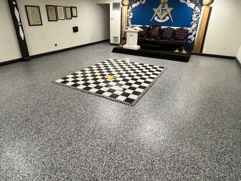 Completed Domino flake epoxy floor replacing old checkered tile in Miami lodge after professional installation by GonzaBuilt