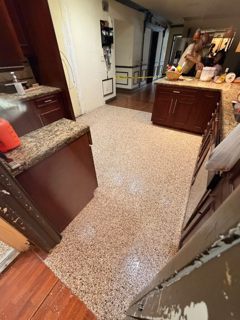 Completed multi-room epoxy floor transformation covering garage kitchen and patio after professional installation by GonzaBuilt in Plantation, Florida